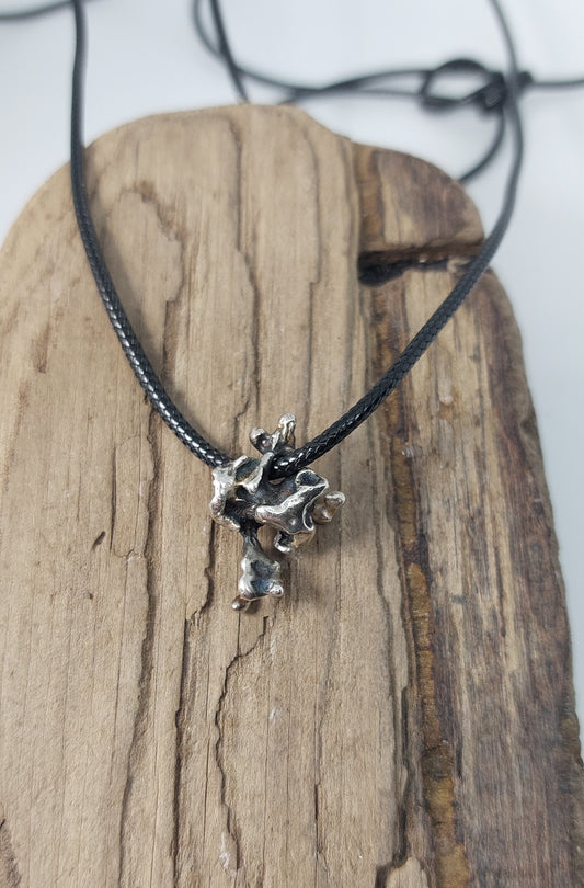 Handmade sterling silver pendant inspired by organic growth, movement, and raw natural forms.
