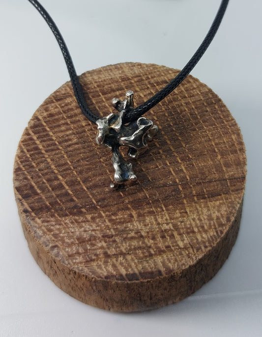 Handmade sterling silver pendant inspired by organic growth, movement, and raw natural forms.